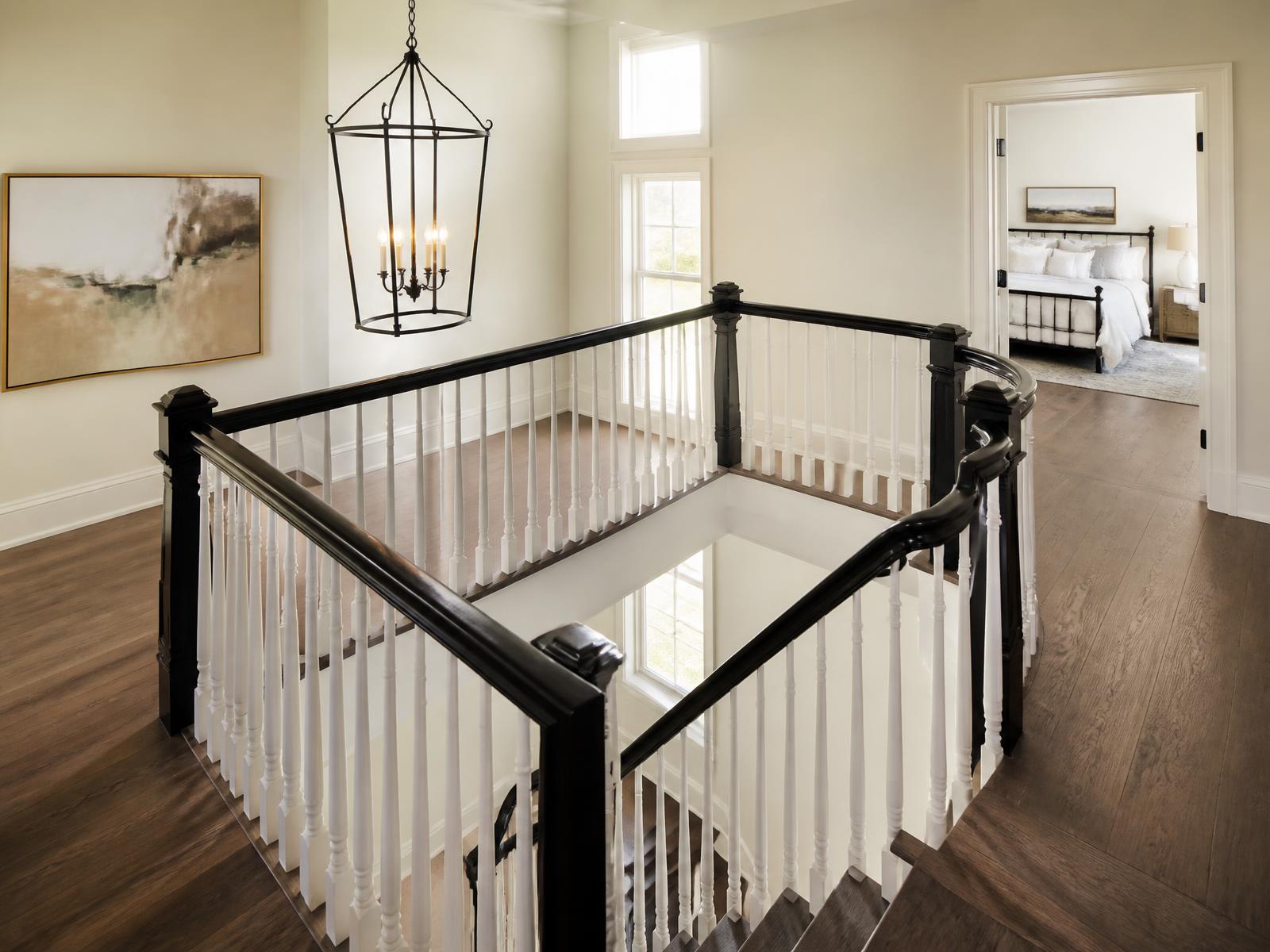 Black handrail over crisp white spindles